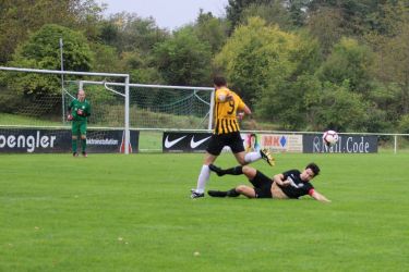 Auf dem durch den einsetzenden Regen glitschig gewordenen Rasen zeigte Spielführer Jonathan Benz seine Klasse und stoppte den Angreifer Marco Hofstetter (9) mit einer Grätsche. Torhüter Daniel Schmieder rechnet schon mit seinem Einsatz.